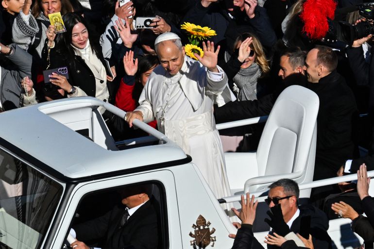 Pope Leo XIV (C) waves to the crowd as he stands on the popemobile while leaving at the end of the Jubilee of Choirs and Choral Society mass at St Peter's Square, in The Vatican, on November 23, 2025. (Photo by Andreas SOLARO / AFP)