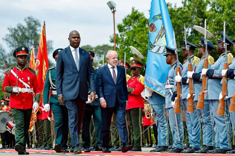 afp_692570bb6638-1764061371 Mozambique's President Daniel Chapo and Brazil's President Luiz Inacio Lula da Silva review a guard of honor in Maputo on November 24, 2025. (Photo by Amilton Neves / AFP)