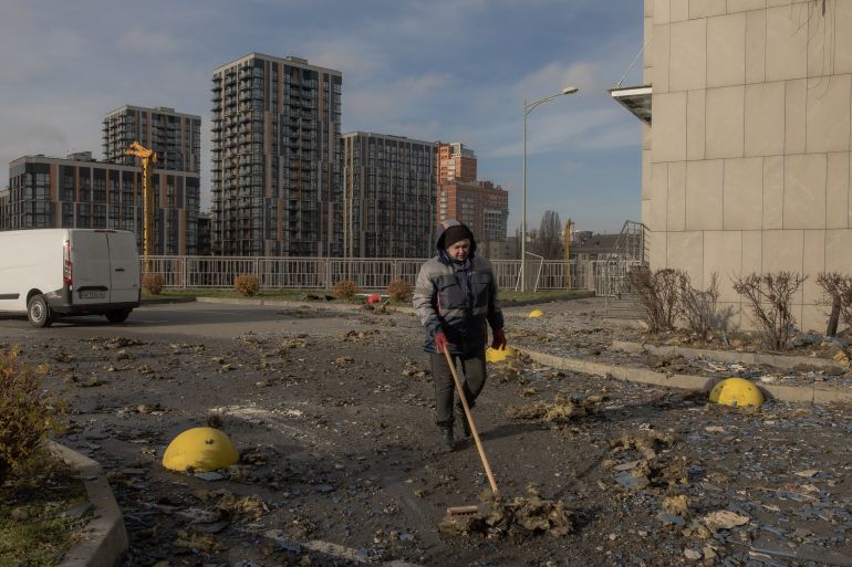 afp_69258e47791b-1764068935 A communal worker cleans debris outside a damaged residential building following Russian missiles and drones strikes in Kyiv on November 25, 2025, amid Russian invasion in Ukraine.