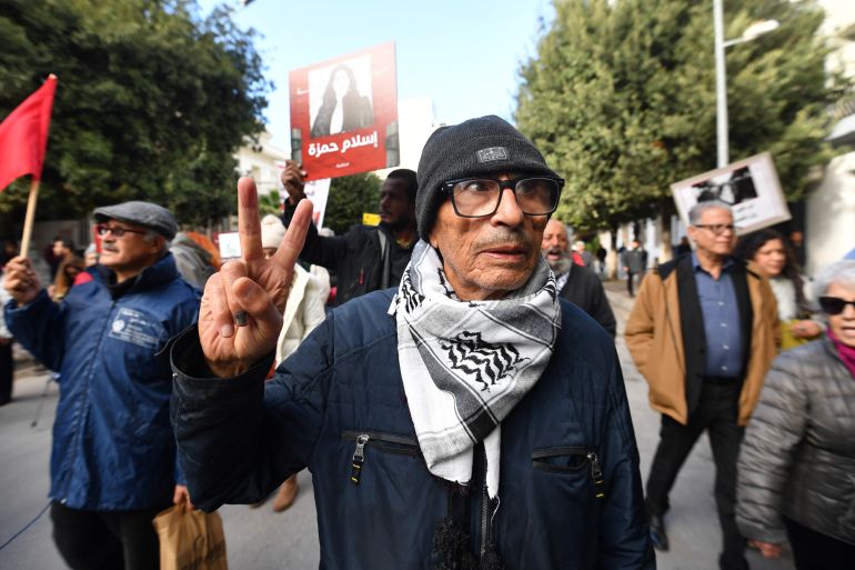 afp_692b3ca6e605-1764441254 Activist Ezzedine Hazgui, 79, father of political prisoner Jawhar ben Mbarek, flahses the V-sign during a demonstration organised by NGOs and political parties demanding the release of political prisoners and greater freedom of expression in Tunis on November 29, 2025.