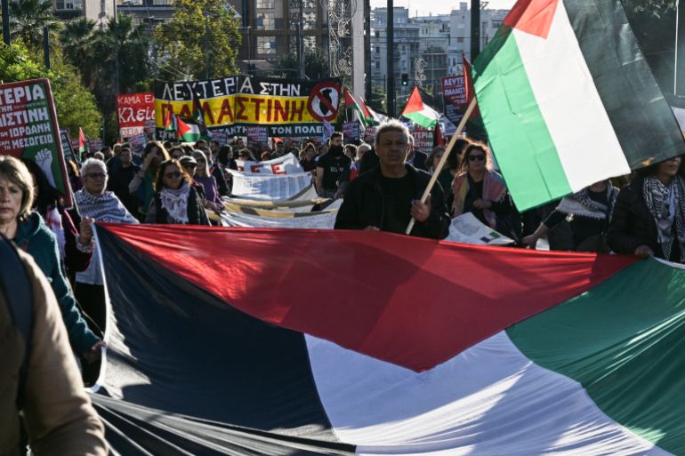 afp_692b42a5dc3c-1764442789 Protesters hold Palestinian flags as they march towards the Israeli embassy during a demonstration in solidarity with Palestinians, in Athens on November 29, 2025. (Photo by Aggelos NAKKAS / AFP)