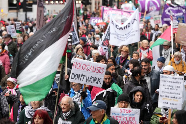 afp_692b71cb306c-1764454859 Protesters hold placards and wave Palestinian flags during a march organised by the Palestine Solidarity Campaign in central London on November 29, 2025, calling to "end the occupation, end apartheid and stop arming Israel".