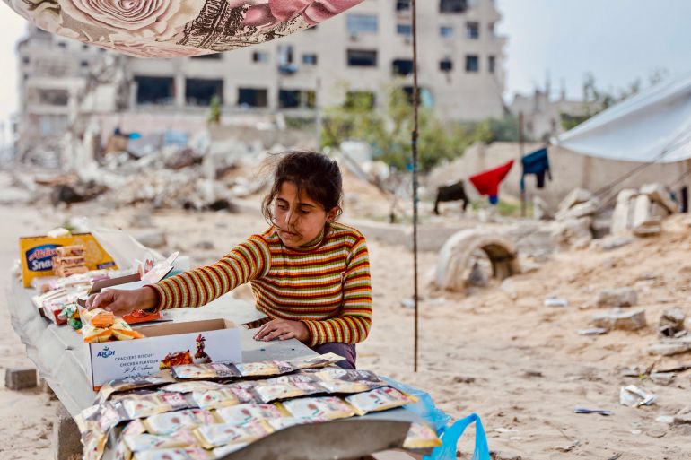 afp_692c03ab106a-1764492203 A displaced Palestinian girl arranges a stall to sell food in the Tel al-Hawa neighborhood, in the southern part of Gaza City, on November 29, 2025.