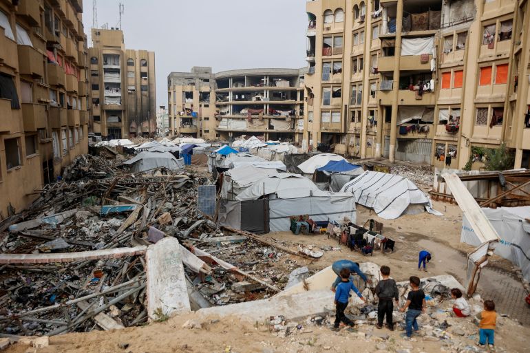 afp_692c03bdafd9-1764492221 Displaced Palestinian children walk through makeshift shelters in the Tel al-Hawa neighborhood, in the southern part of Gaza City, on November 29, 2025.