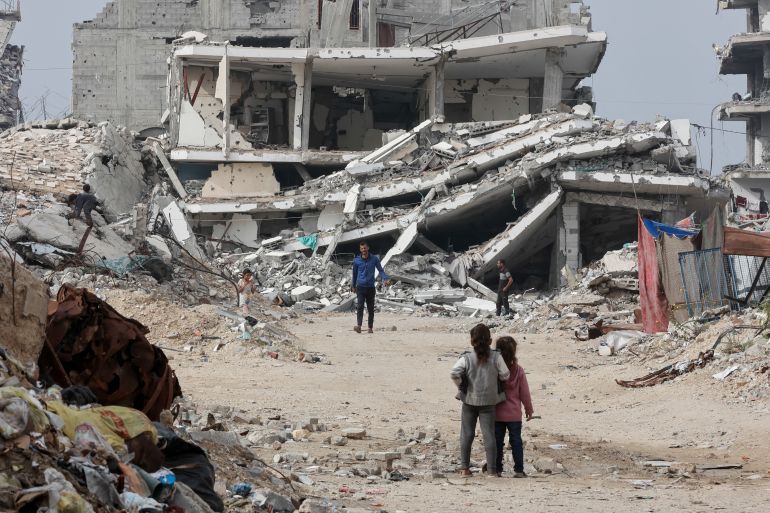 afp_692c03ccb301-1764492236 Displaced Palestinians walk past destroyed buildings in the Tel al-Hawa neighborhood, in the southern part of Gaza City, on November 29, 2025.