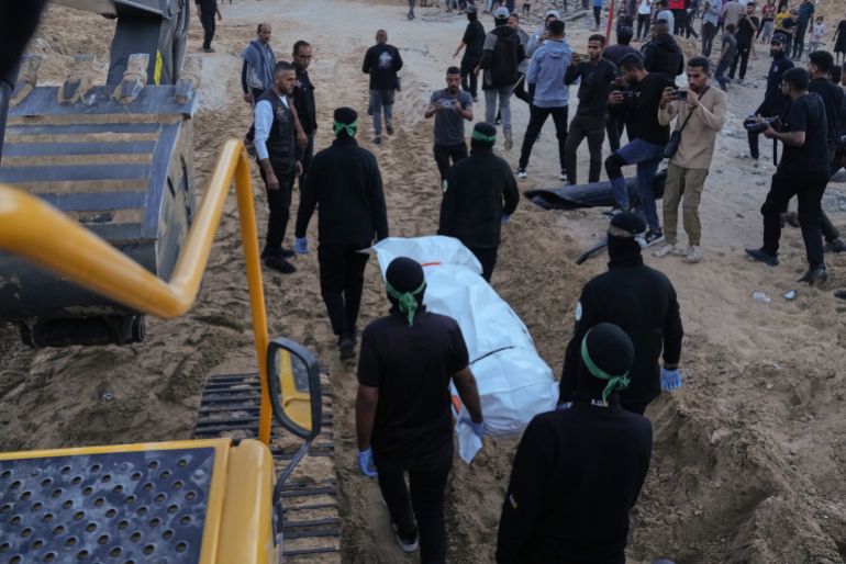 Hamas militants carry a white bag believed to contain a body, after retrieving it from a tunnel during a search for the remains of hostages in Hamad City, Khan Younis, in southern Gaza, Tuesday, Oct. 28, 2025. (AP Photo/Jehad Alshrafi)