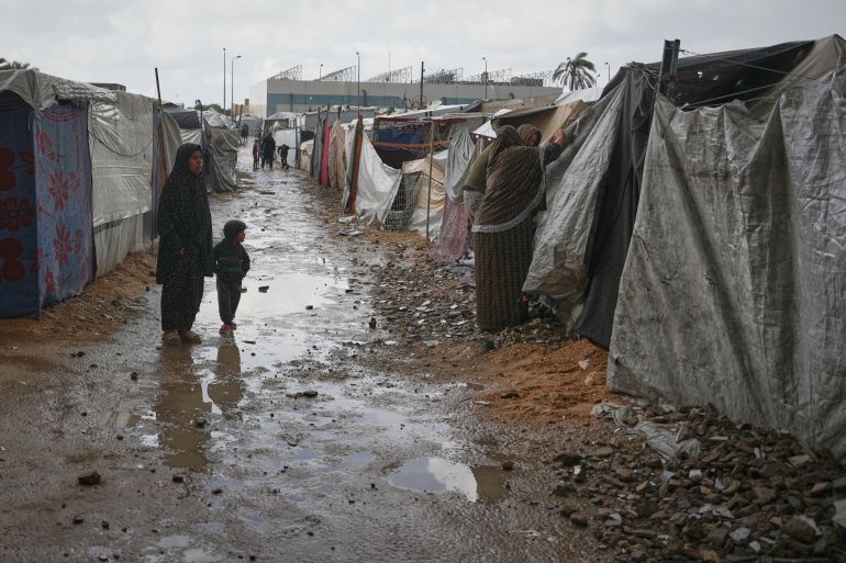 ap_69197e6dbb82d-1763278445 Hussein and Khawla Abu Arabiya adjust their tent to protect the interior from a rainstorm at a temporary camp in Deir al-Balah, in the central Gaza Strip, on Friday, Nov. 14, 2025. (AP Photo/Abdel Kareem Hana)