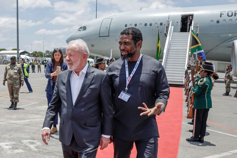 ap_69206a268eadb-1763732006 Brazil's President Luiz Inacio Lula da Silva, left is welcomed by South Africa's Higher Education Minister Buti Manamela upon his arrival at the OR Tambo International airport in Ekurhuleni on Friday, Nov. 21, 2025 ahead of the G20 leaders' Summit. ( Marco Longari /Pool Photo via AP)