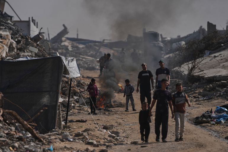 ap_69209a36d40b2-1763744310 Displaced Palestinians light a fire to keep away mosquitoes amid the destruction left by Israeli air and ground offensive in Jabalia, Gaza, Friday, Nov. 21, 2025. (AP Photo/Jehad Alshrafi)