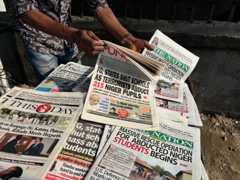 ap_6922acaa18e09-1763880106 A street vendor in Lagos displays local newspapers with headlines on gunmen abducting schoolchildren and staff of the St. Mary's Catholic Primary and Secondary School in Papiri community in Nigeria, Saturday, Nov. 22, 2025. (AP Photo/Sunday Alamba )