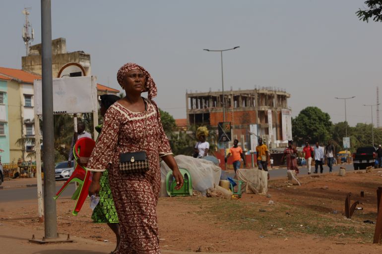 ap_6928593a07d3a-1764251962 People walk on the street in Bissau, Guinea-Bissau, Wednesday, Nov. 26, 2025. (AP Photo/Darcicio Barbosa)
