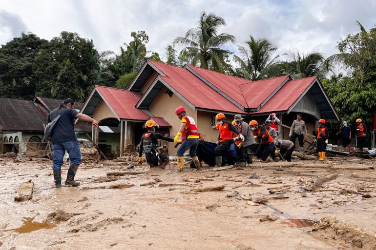 ap_692c75fa853c6-1764521466 Rescuers carry the body of a flood victim, in Agam, West Sumatra, Indonesia, Sunday, Nov. 30, 2025. (AP Photo/Ade Yuandha)