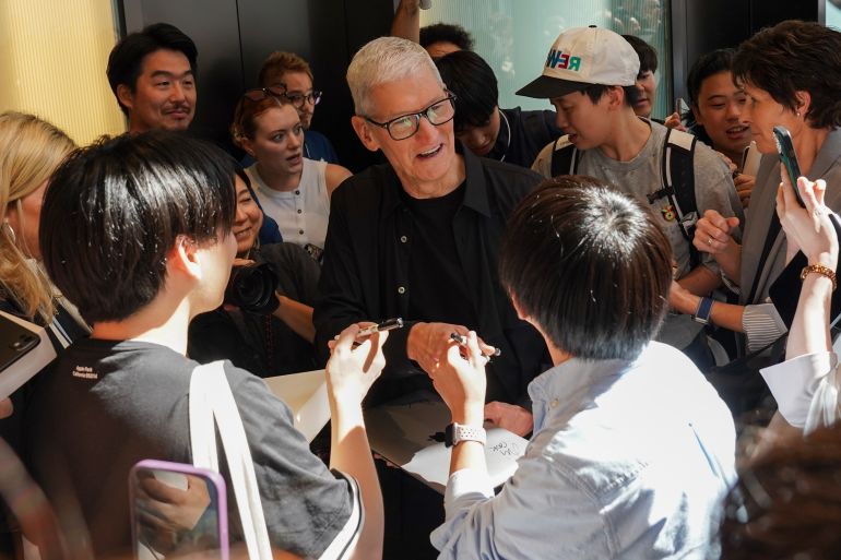 TOKYO, JAPAN - SEPTEMBER 26: Apple CEO Tim Cook (C) speaks with people during the reopening of the Apple Ginza store on September 26, 2025 in Tokyo, Japan. Apple has announced the grand reopening of its flagship Apple Ginza store in Tokyo's vibrant Ginza district, where the company's Japanese retail journey began over two decades ago. Initially opened in 2003 as Apple's first international store, the renovated location now features an all-new four-story design that showcases Apple's complete range of products, services, and customer experiences in a reimagined space. (Photo by Christopher Jue/Getty Images)