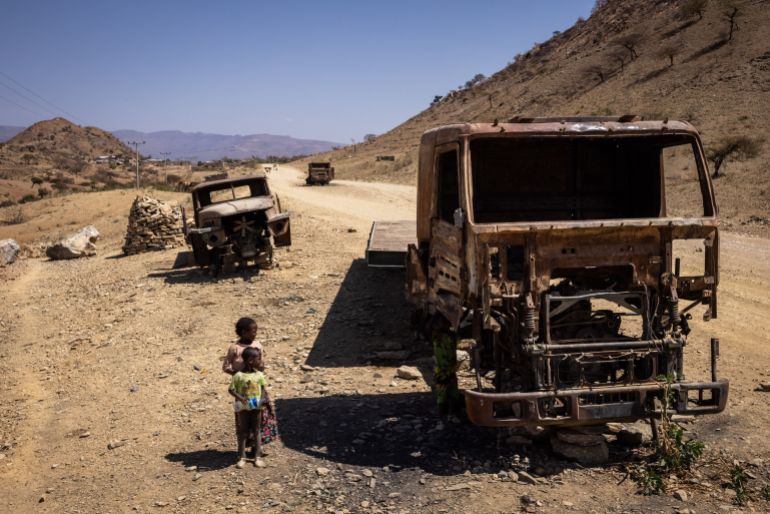 TIGRAY, ETHIOPIA - FEBRUARY 18: Children look at burnt trucks that were destroyed during the war in Tigray on February 18, 2024 in Tigray Region, Ethiopia. More than 20 million Ethiopians are in need of food aid, according to estimates from the UN's Office for the Coordination of Humanitarian Affairs (UNOCHA). The situation is particularly acute in drought-stricken Tigray, in the country's north, which is still recovering from a two-year war between the Ethiopian government and allied forces on one side, and Tigrayan forces on the other, during which the region's economy was devastated and many were displaced. The combined effects of war and drought have raised the specter of famine, which the federal government in Addis Ababa denies is imminent, saying it is committed to providing aid. (Photo by Ed Ram/Getty Images)