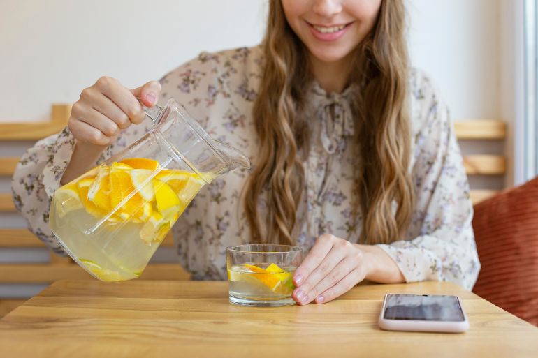 سيدة تصب شراب الليمون بالبرتقال