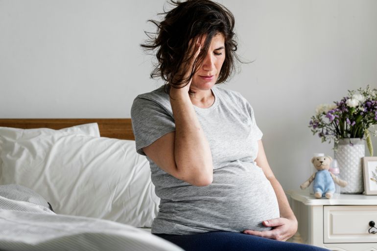 Pregnant woman with a headache; Shutterstock ID 1023536041; purchase_order: aljazeera ; job: ; client: ; other: