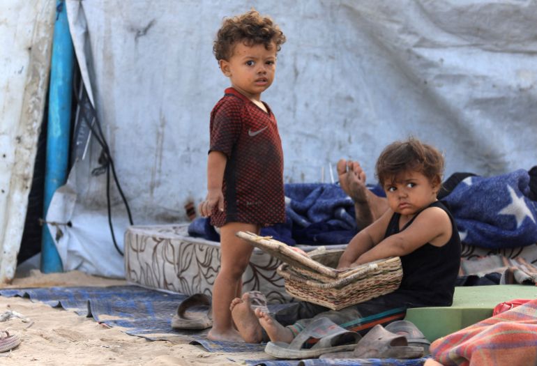 Displaced Palestinian children shelter on the side of a road, after Hamas agreed to release hostages and accept some other terms in a U.S. plan to end the war, in the central Gaza Strip, October 4, 2025. REUTERS/Dawoud Abu Alkas