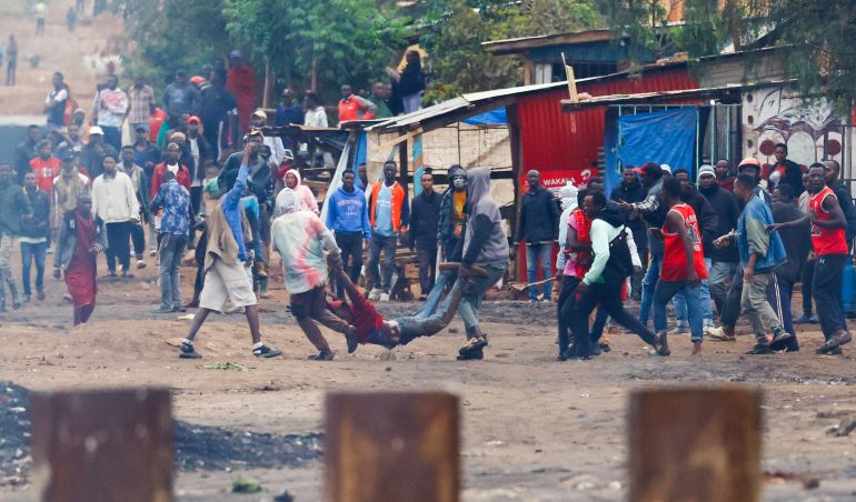 SENSITIVE MATERIAL. THIS IMAGE MAY OFFEND OR DISTURB Demonstrators carry the dead body of a man killed during a protest a day after a general election marred by violent demonstrations over the exclusion of two leading opposition candidates at the Namanga One-Post Border crossing point between Kenya and Tanzania, as seen from Namanga, Kenya October 30, 2025. REUTERS/Thomas Mukoya