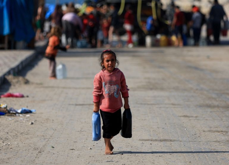 A Palestinian child carries water containers, amid a ceasefire between Israel and Hamas, in Gaza City November 19, 2025. REUTERS/Dawoud Abu Alkas