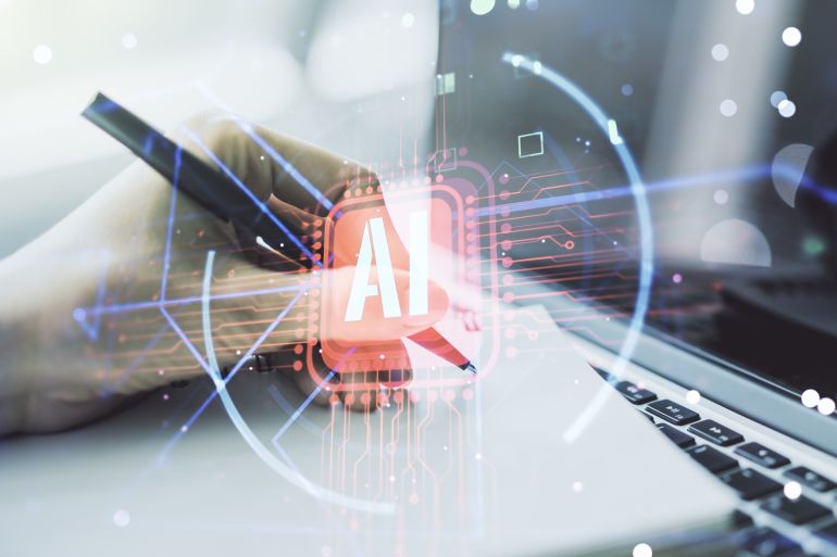 Double exposure of creative artificial Intelligence abbreviation with hand writing in notepad on background with laptop. Future technology and AI concept