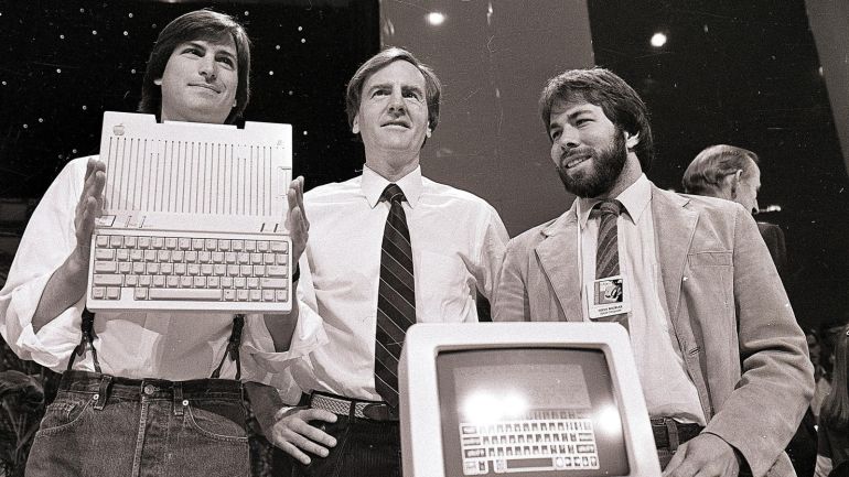 11199384-968c-43f3-9a1d-4b982accdf85 FILE - In this April 24, 1984 file photo, Steve Jobs, left, chairman of Apple Computers, John Sculley, center, president and CEO, and Steve Wozniak, co-founder of Apple, unveil the new Apple IIc computer in San Francisco. “Steve Jobs,” released Friday, Oct. 9, 2015, is the latest movie to examine a charismatic visionary who mesmerized the masses with his trendsetting gadgets while alienating his subordinates and friends with an almost-inhumane cruel streak. The story is told through Jobs’ interactions with six central figures in his life: his former marketing chief, Joanna Hoffman; his former girlfriend Chrisann Brennan; Apple co-founder and friend Wozniak; former Apple engineer Andy Hertzfeld; former Apple CEO Sculley; and Lisa, the daughter that Jobs refused to acknowledge for many years. (AP Photo/Sal Veder, File)