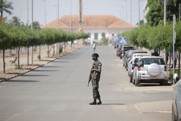 51112-1764180129 غينيا بيساو A soldier holds his weapon while patrolling a street near the scene of gunfire near the Presidential Palace in Bissau on November 26, 2025. Gunfire was heard Wednesday outside Guinea-Bissau's presidential palace just three days after the country's presidential and legislative elections, with both major candidates have claimed victory, an AFP journalist on the scene witnessed. People were seen running in a crowd gathered outside the palace as the shots were heard. (Photo by Patrick MEINHARDT / AFP)