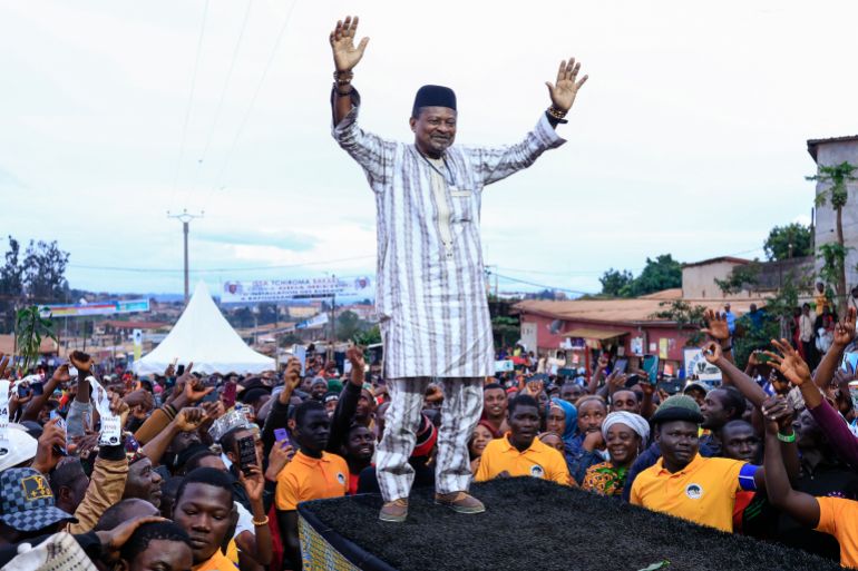 afp_692e5c7757ea-1764646007 Anicet Ekane (C), politician and president of the MANIDEM party, greets the crowd on September 24, 2025 at a rally for candidate Issa Bakary Tchiroma (non seen), whom he is supporting in the October 12, presidential election.