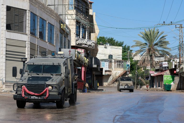 afp_692f6e2cbbe5-1764716076 Israeli military vehicles are driven in an empty street during a military operation in the city of Tubas, north of the occupied West bank, on December 1, 2025.