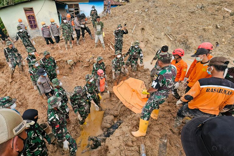 afp_692ff0bf5fff-1764749503 EDITORS NOTE: Graphic content / This handout picture taken on December 2, 2025 and released on December 3, 2025 by Indonesia's National Disaster Agency (BASARNAS) shows military, police and rescue personnel retrieving two bodies after digging through mud at Sibalanga village in North Tapanuli, North Sumatra province, after flash floods hit the area.