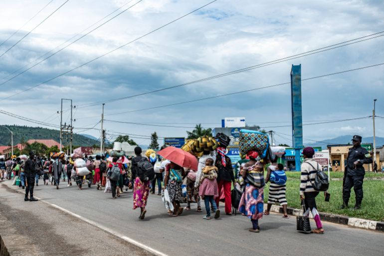 afp_69351a223801-1765087778-1 TOPSHOT - Members of the Rwandan security forces accompany a group freshly displaced people from the Democratic Republic of Congo in Bugarama on December 5, 2025 as they arrive in Rwanda after fleeing intense shelling in the bordering Kamanyola region.
