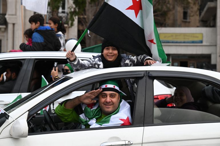 afp_6937e0e6092c-1765269734 A boy waves a Syrian flag as they celebrate a year since the ousting of longtime ruler Bashar al-Assad in the Syrian capital Damascus on December 8, 2025.