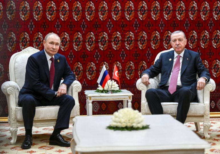 In this pool photograph distributed by the Russian state agency Sputnik, Russia's President Vladimir Putin and Turkish President Recep Tayyip Erdogan hold a meeting in Ashgabat on December 12, 2025.