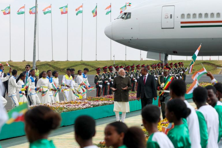 This handout photograph taken on December 16, 2025 and released by the Indian Press Information Bureau (PIB) shows India's Prime Minister Narendra Modi (centre L) along with his Ethiopian counterpart Abiy Ahmed Ali (centre R) during a ceremonial reception at Addis Ababa Bole International Airport in Addis Ababa, Ethiopia.