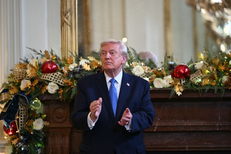afp_69478652b7aa-1766295122 US President Donald Trump applauds during a Hanukkah reception in the East Room of the White House in Washington, DC, on December 16, 2025. (Photo by ANDREW CABALLERO-REYNOLDS / AFP)