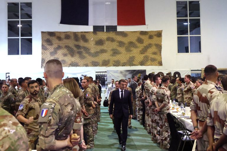 afp_69483d5625b6-1766341974 French President Emmanuel Macron arrives for Christmas diner with troops of the 5th Cuirassier Regiment's base in Zayed Military City, near Abu Dhabi, on December 21, 2025.