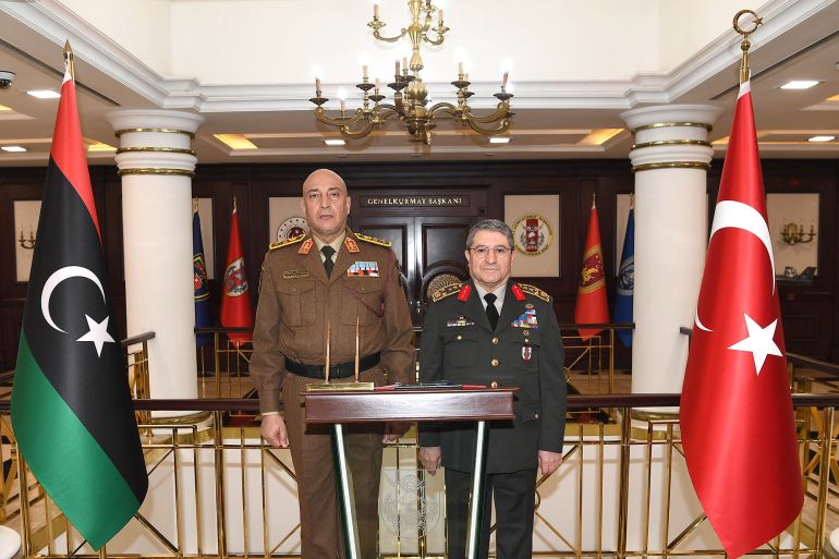 ali-2-1766521531 This handout photograph taken and released by the Turkish Defence Ministry on December 23, 2025, shows Turkey's Defence Minister Yasar Guler (R) and Lybia's Chief of the General Staff, General Muhammad Ali Ahmad al-Haddad posing during their meeting in Ankara. The wreckage of the plane carrying the Libyan chief of staff, which disappeared shortly after taking off from Ankara in the evening of December 23, 2025, has been found, the Turkish interior minister has announced. "The wreckage of the plane that took off from Ankara-Esenboga Airport bound for Tripoli was found by our gendarmerie forces 2 km south of the village of Kesikkavak, in the district of Haymana," about 50 km southeast of the Turkish capital, Minister Ali Yerlikaya announced on X. (Photo by Handout / TURKISH DEFENCE MINISTRY / AFP) / RESTRICTED TO EDITORIAL USE - MANDATORY CREDIT "AFP PHOTO / TURKISH DEFENCE MINISTRY" - NO MARKETING NO ADVERTISING CAMPAIGNS - DISTRIBUTED AS A SERVICE TO CLIENTS