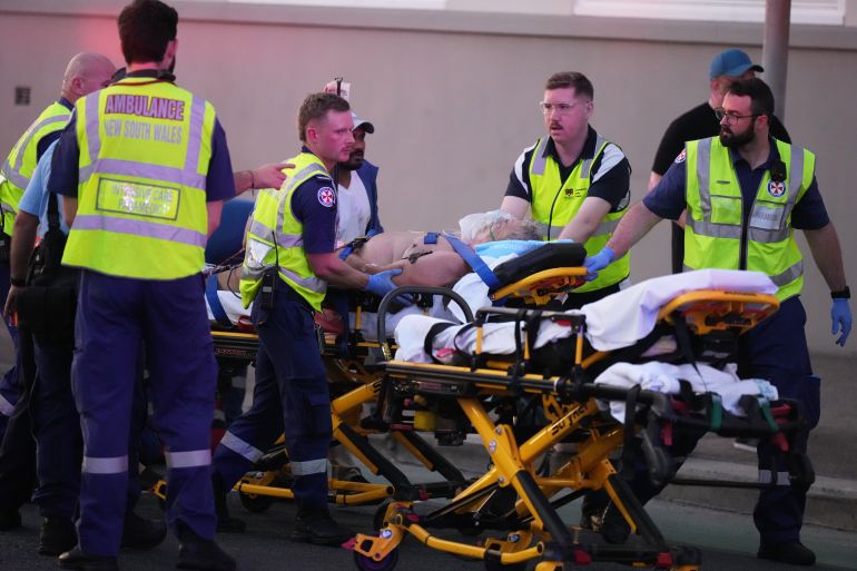 ap25348334327557-1765706224 Emergency workers transport a person on a stretcher after a reported shooting at Bondi Beach in Sydney, Sunday, Dec. 14, 2025. (AP Photo/Mark Baker)