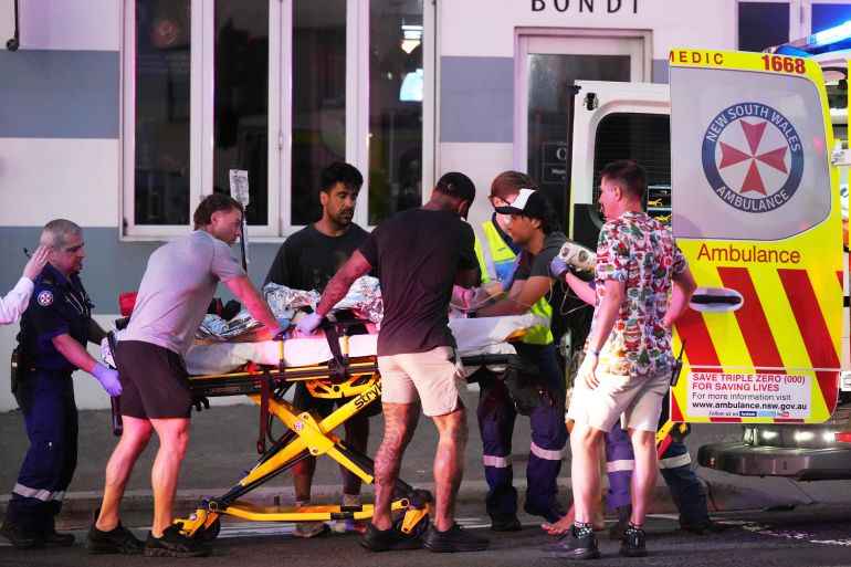 ap25348337848527-1765706338 Emergency workers transport a person on a stretcher after a reported shooting at Bondi Beach in Sydney, Sunday, Dec. 14, 2025. (AP Photo/Mark Baker)