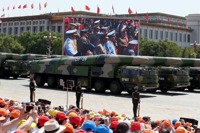 ap701716791570 الصاروخ الصيني "دونغ فينغ -26" Foreign military officers are displayed on a big screen as they watch military vehicles carry DF-26 medium-range ballistic missiles during a parade commemorating the 70th anniversary of Japan's surrender during World War II held in front of Tiananmen Gate in Beijing, Thursday, Sept. 3, 2015. The spectacle involved more than 12,000 troops, 500 pieces of military hardware and 200 aircraft of various types, representing what military officials say is the Chinese military's most cutting-edge technology. (AP Photo/Ng Han Guan)
