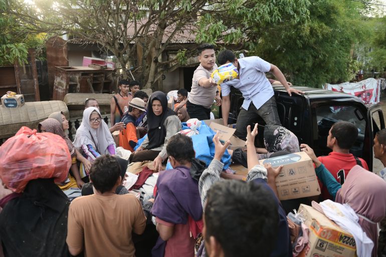 ap_693001587cc06-1764753752 Volunteers distribute relief goods to survivors at a village affected by flash flood in Pidie Jaya, Aceh province, Indonesia, Tuesday, Dec. 2, 2025. (AP Photo/Reza Saifullah)