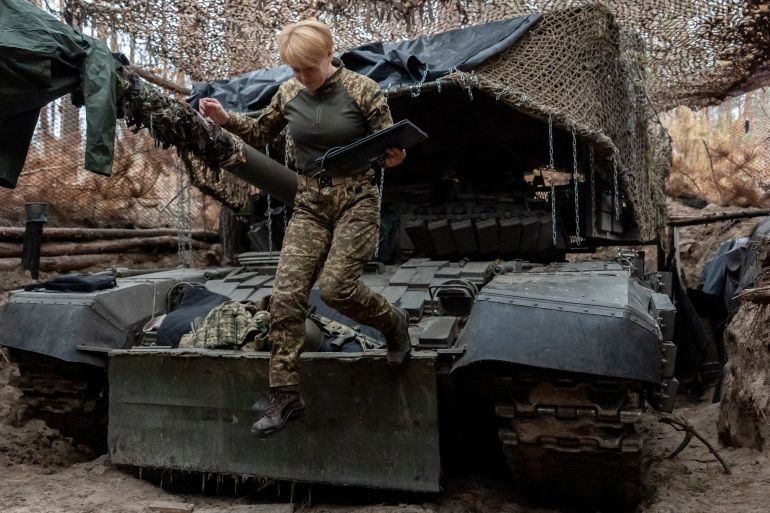 A Ukrainian soldier from the Khartia brigade, callsign Muza, jumps down from a tank following a demonstration for The Associated Press, Thursday, Nov. 6, 2025, in Kharkiv Oblast, Ukraine. (AP Photo/Julia Demaree Nikhinson)
