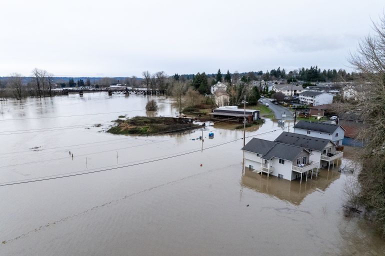 ap_693bc926d8198-1765525798 An aerial view of homes surrounded by floodwaters in Snohomish, Wash., Thursday, Dec. 11, 2025. (AP Photo/Stephen Brashear)