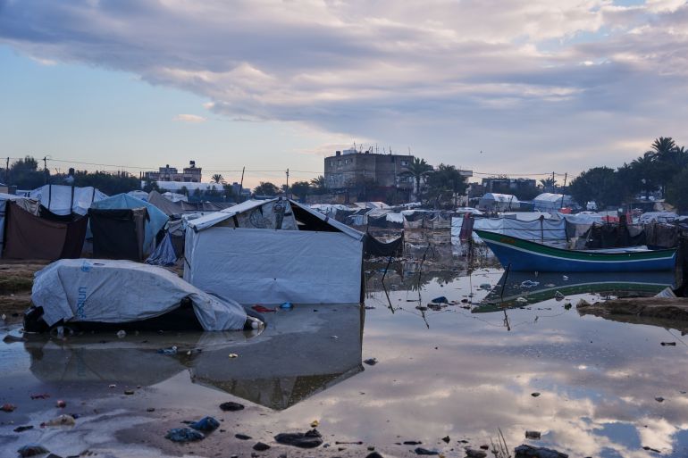 A car is seen partially submerged next to a small boat in a flooded area after heavy rains in a makeshift camp for displaced Palestinians in Zawaida, central Gaza Strip, Wednesday, Dec. 17, 2025. (AP Photo/Abdel Kareem Hana)