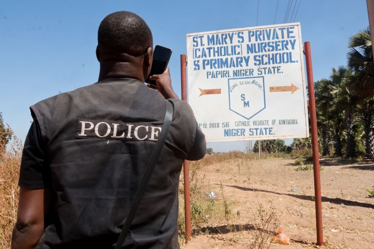 epa_692572f44413-1764061940 epa12545995 A member of the security forces takes photos of St. Mary's Private Catholic School signage in Papiri, Niger State, Nigeria, 24 November 2025. Fifty of the 303 schoolchildren abducted from the school have escaped captivity and reunited with their families, according to the Christian Association of Nigeria (CAN). EPA/AFOLABI SOTUNDE