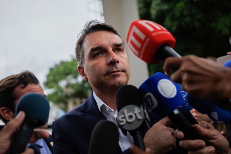 epa_69344d59a9c2-1765035353 epa12547736 Senator Flavio Bolsonaro speaks with reporters upon his arrival at the Federal Police Headquarters to visit his father, former Brazilian President Jair Bolsonaro, who is being held there, in Brasília, Brazil, 25 November 2025. EPA/Isaac Fontana