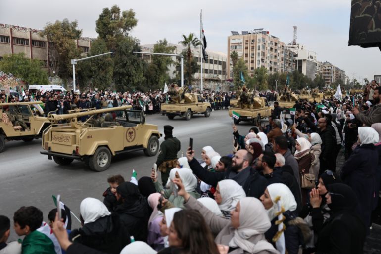DAMASCUS, SYRIA - DECEMBER 8: Soldiers and military vehicles parade through the streets to mark one year since the fall of the Assad regime on December 8, 2025 in Damascus, Syria. The first anniversary of the fall of the Assad regime in Syria is being marked today across the country. Former leader Bashar al-Assad was granted asylum in Russia after he fled the country and his government collapsed on December 8, 2024. The fall of the regime, which ended over five decades of the Assad family's rule, came after a rapid offensive by opposition forces led by Hayat Tahrir al-Sham (HTS). A transitional government, headed by Ahmed al-Sharaa (formerly the HTS leader), is now in place and working on the country's reconstruction and political transition.  (Photo by Chris McGrath/Getty Images)
