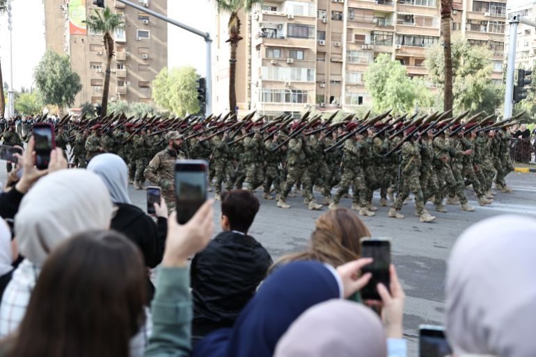 DAMASCUS, SYRIA - DECEMBER 8: Soldiers march in formation during a parade marking the first anniversary of the overthrow of the Assad regime on December 8, 2025 in Damascus, Syria. The first anniversary of the fall of the Assad regime in Syria is being marked today across the country. Former leader Bashar al-Assad was granted asylum in Russia after he fled the country and his government collapsed on December 8, 2024. The fall of the regime, which ended over five decades of the Assad family's rule, came after a rapid offensive by opposition forces led by Hayat Tahrir al-Sham (HTS). A transitional government, headed by Ahmed al-Sharaa (formerly the HTS leader), is now in place and working on the country's reconstruction and political transition.  (Photo by Chris McGrath/Getty Images)