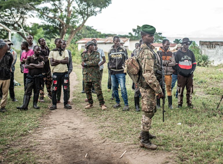 getty_69411b4053-1765874496 UVIRA, DEMOCRATIC REPUBLIC OF CONGO - DECEMBER 15: An M23 fighter looks on as Wazalendo militants surrender weapons to the Rwanda-backed M23 rebel group on December 15, 2025 in Uvira, Democratic Republic of Congo. Fifty-two members from the coalition of Congolese and Burundian militias known as the Wazalendo joined M23 following the rebels' capture of the South Kivu city on December 10. Human Rights Watch has reported abuses perpetrated against civilians by fighters from both sides of the conflict during the offensive on Uvira, and has called for the safe passage and humanitarian assistance for those caught up in the fighting. (Photo by Daniel Buuma/Getty Images)