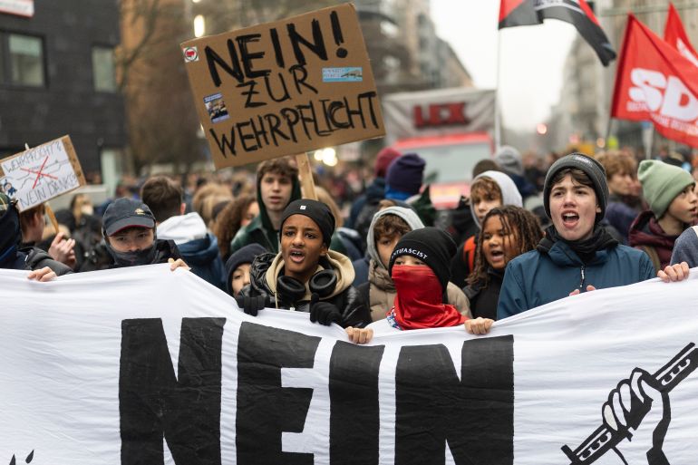 BERLIN, GERMANY - DECEMBER 05: Young protesters hold a banner that reads "No to military conscription" on December 05, 2025 in Berlin, Germany. School strikes to protest against military conscription are taking place nationwide today. German lawmakers have approved a government plan to sharply boost military recruitment as the country seeks to strengthen its forces amid growing concerns over the Russian threat. (Photo by Maja Hitij/Getty Images)