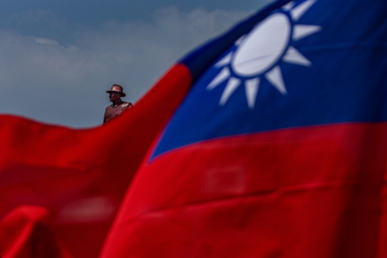 getty_69438ac762-1766034119 KINMEN, TAIWAN - SEPTEMBER 24: A bronze statue of the former leader of Republic of China, Chiang Kai-shek, is seen behind the national flag of Taiwan on September 24, 2022 in Kinmen, Taiwan. Kinmen, an island in the Taiwan strait that is part of Taiwan's territory, is so close to China that the deep-water port of Xiamen, one of China's biggest, lies less than three miles away across the water. It is one of the few areas of Taiwan that mainland Chinese tourists can visit without visas or permits, and has deep ties with the adjacent Fujian province of China. Wartime anti-tank barricades litter the beach on the island, which also feature the Zhaishan tunnel that Taiwanese forces still reserve the right to use in wartime and for military exercises. (Photo by Annabelle Chih/Getty Images)